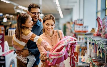 Una familia eligiendo la mochila del cole