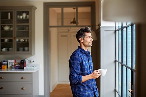 Un hombre bebe una taza de café en casa
