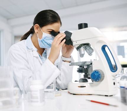 Una investigadora observa a través del microscopio