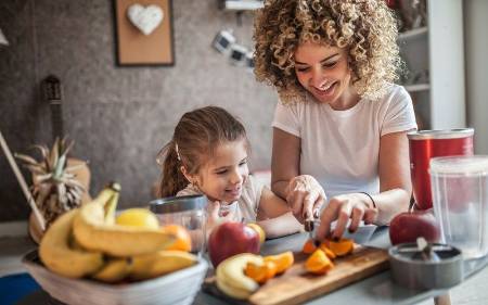 Una madre corta fruta para su hija