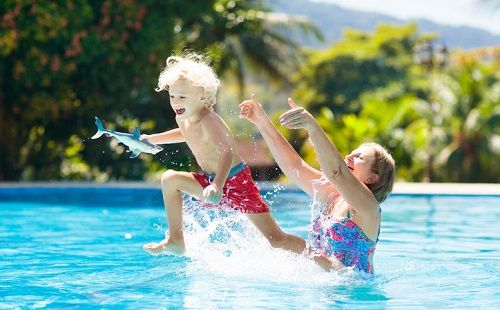 Una madre juega con su hijo en la piscina