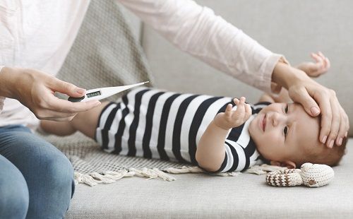 Una madre comprueba la fiebre de su bebé