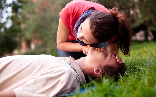 Una mujer escucha la respiración antes de la reanimación cardiopulmonar